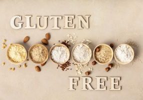 Various gluten free flour almond flour, oatmeal flour, buckwheat flour, rice flour, corn flour and gluten free lettering made of wooden letters, top view, flat lay