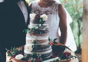 couple standing with a wedding cake